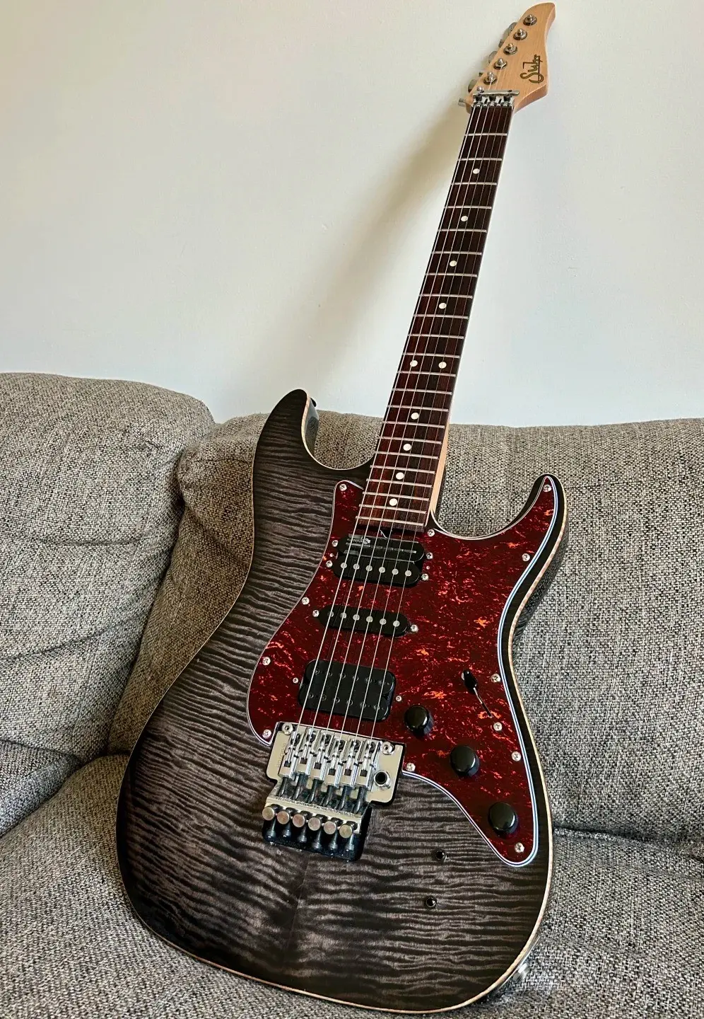 Electric guitar with a flamed top on a sofa