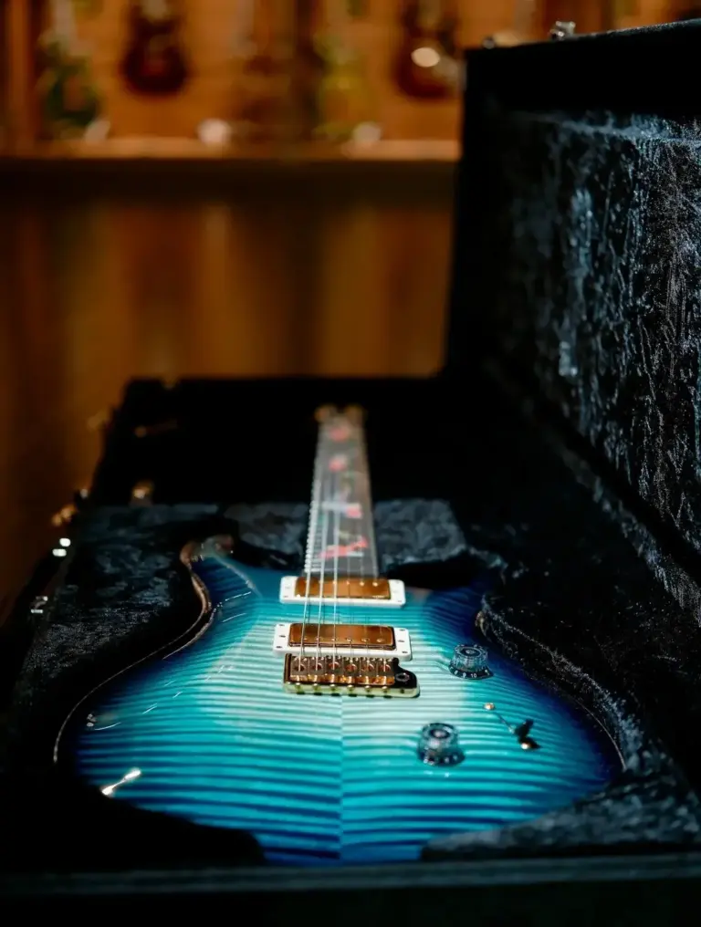 PRS guitar with a blue flamed top in its case