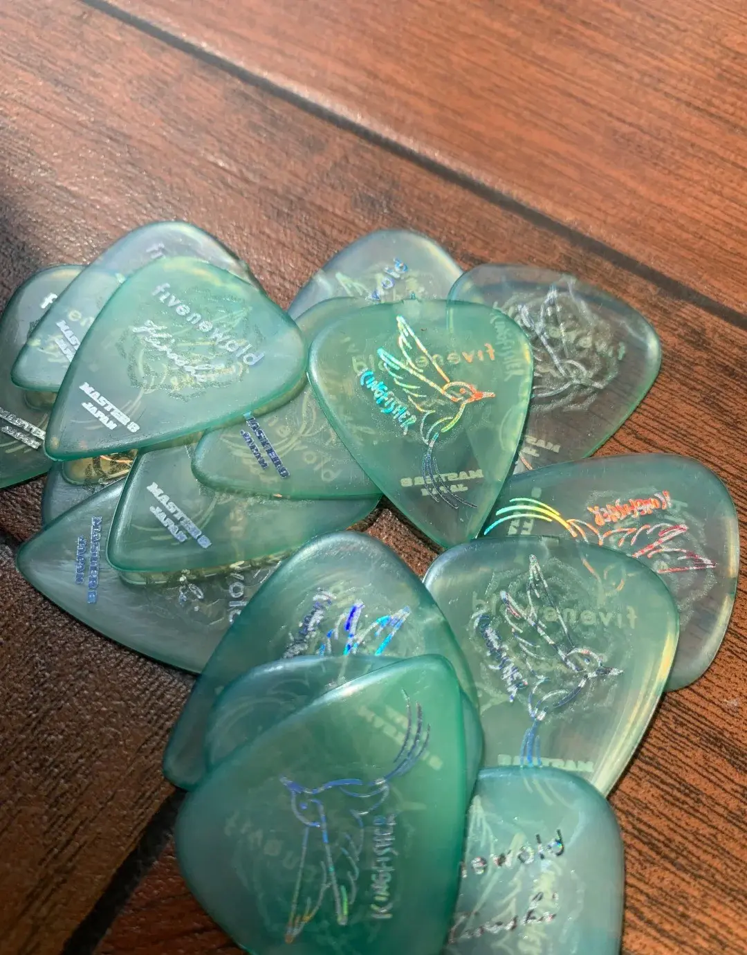 Médiators de guitare verts posés sur du bois